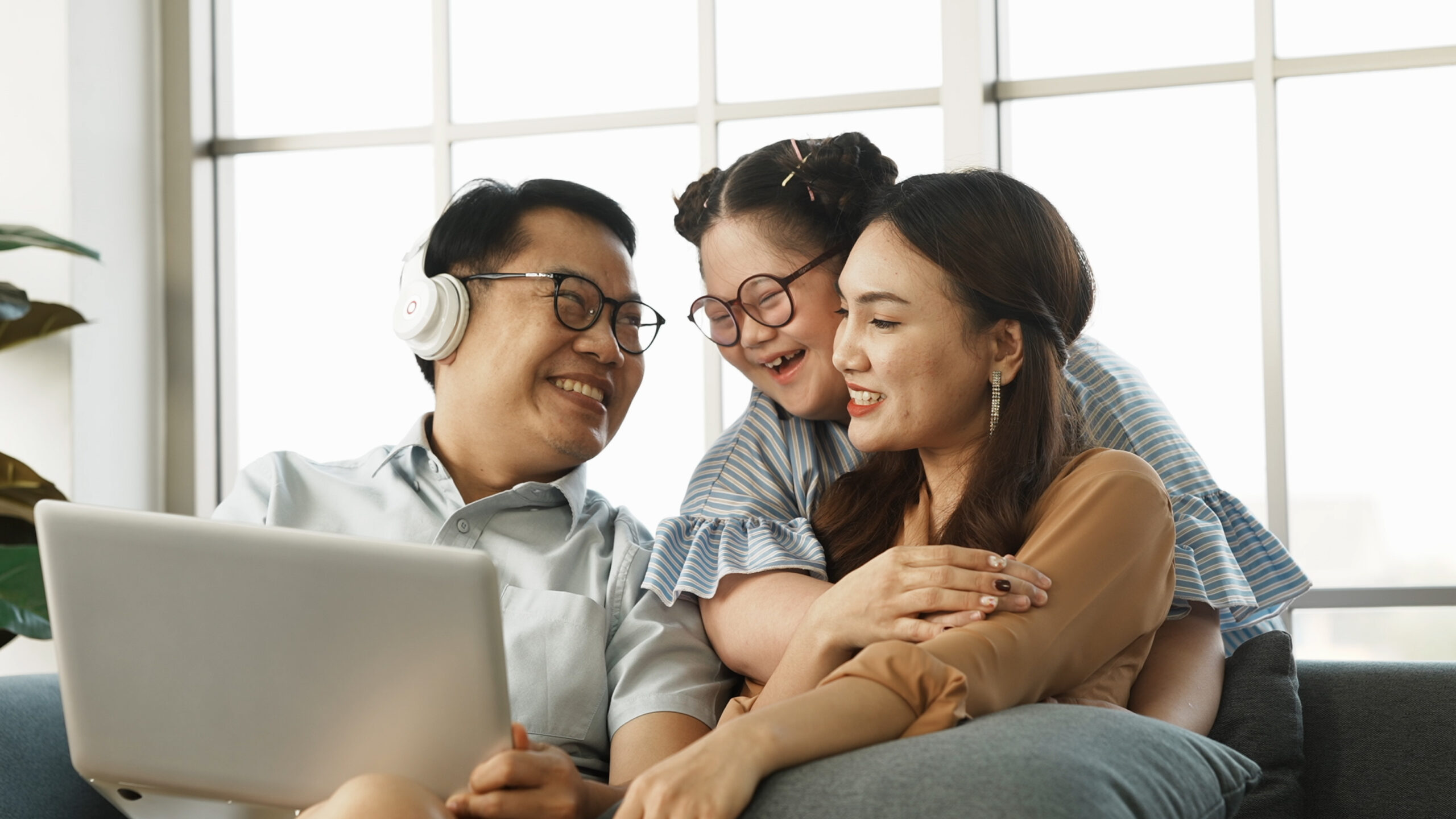 a couple hugging their foster child while in the living room