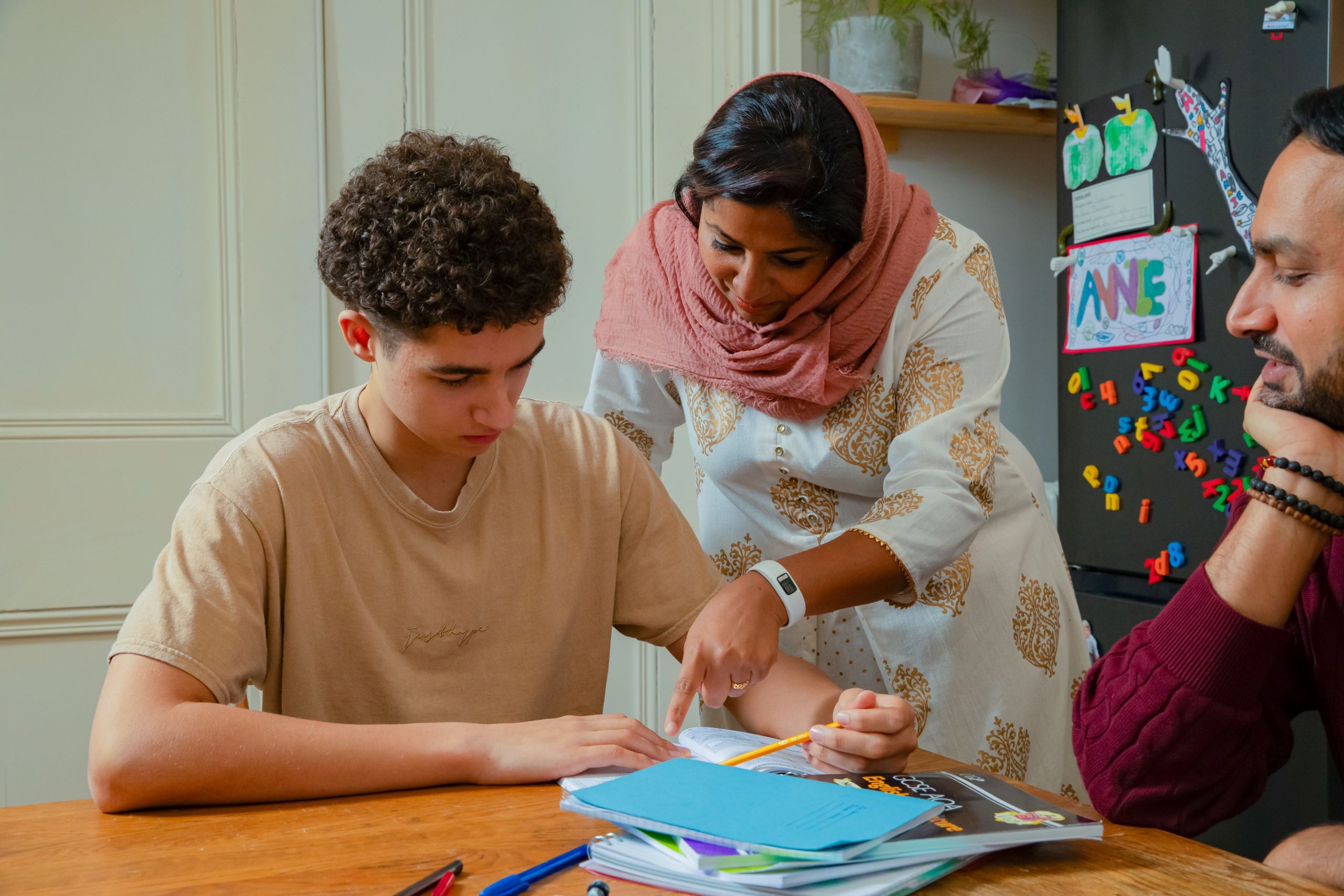 Woman supporting her foster child with homework with her partner