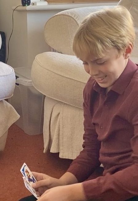 Oliver laughing while he plays UNO with his mum Tracy