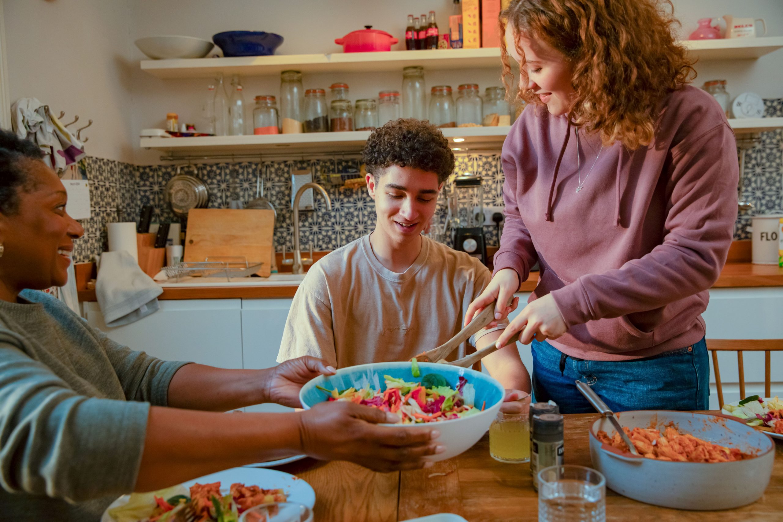 Image: Woman and two young people at a kitchen table