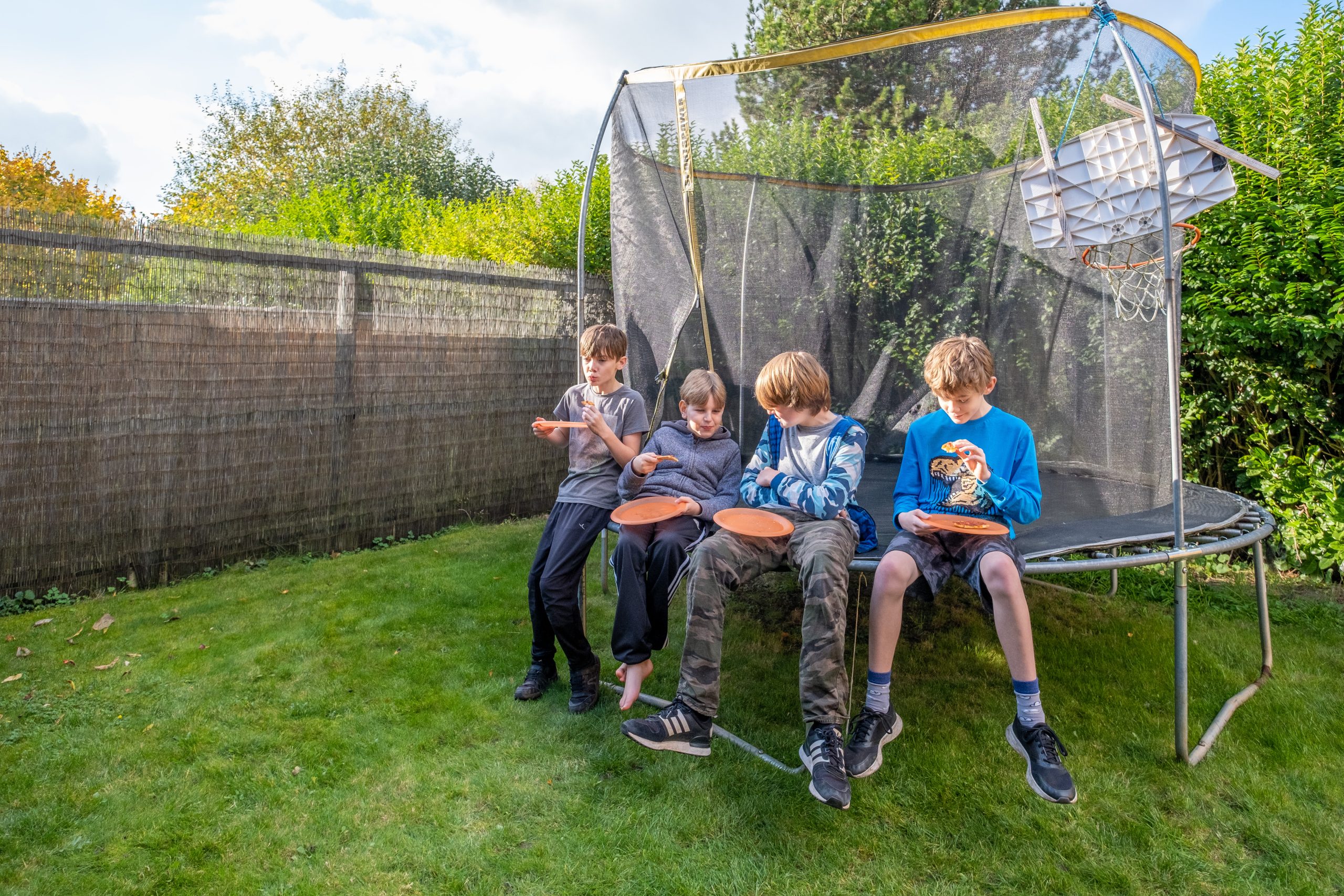 a group of foster children having pizza in the garden together