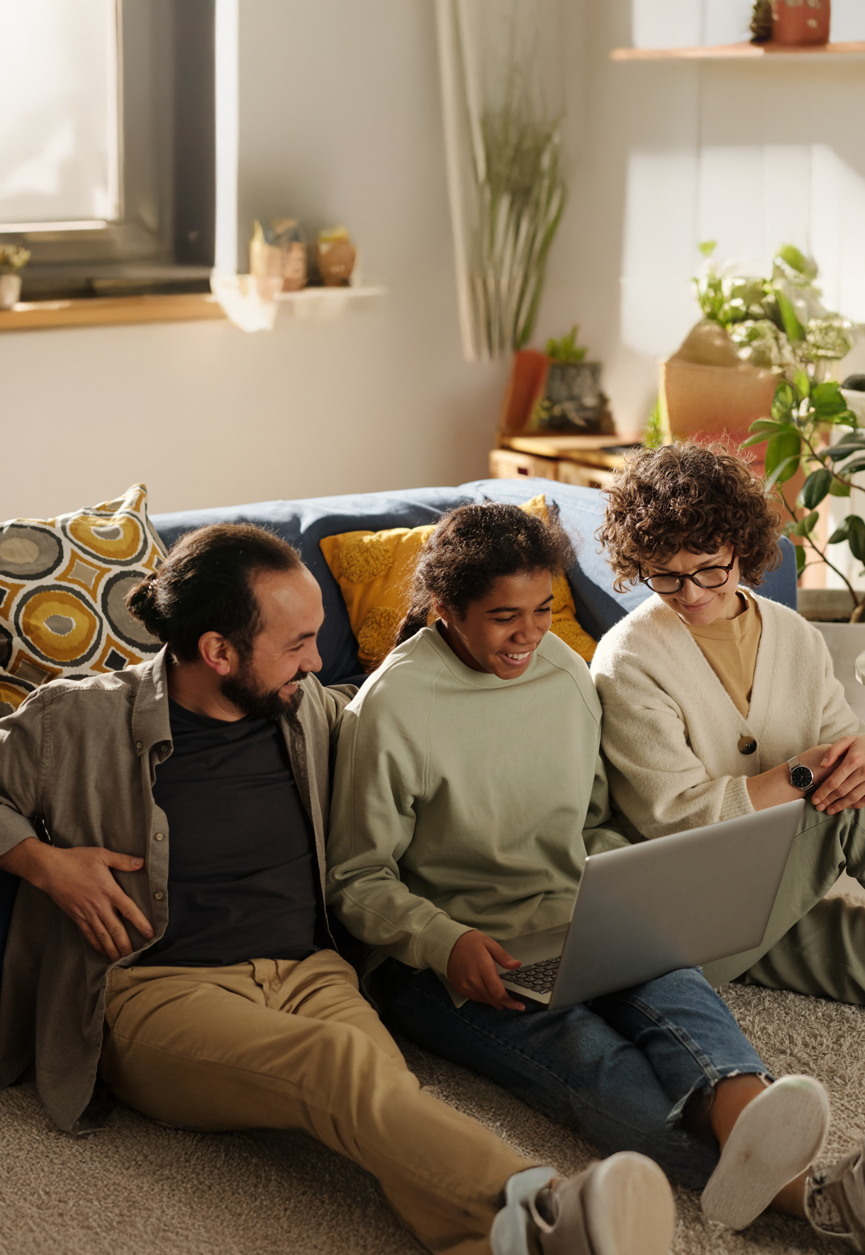 a couple of foster carers looking at a laptop with their looked after young person
