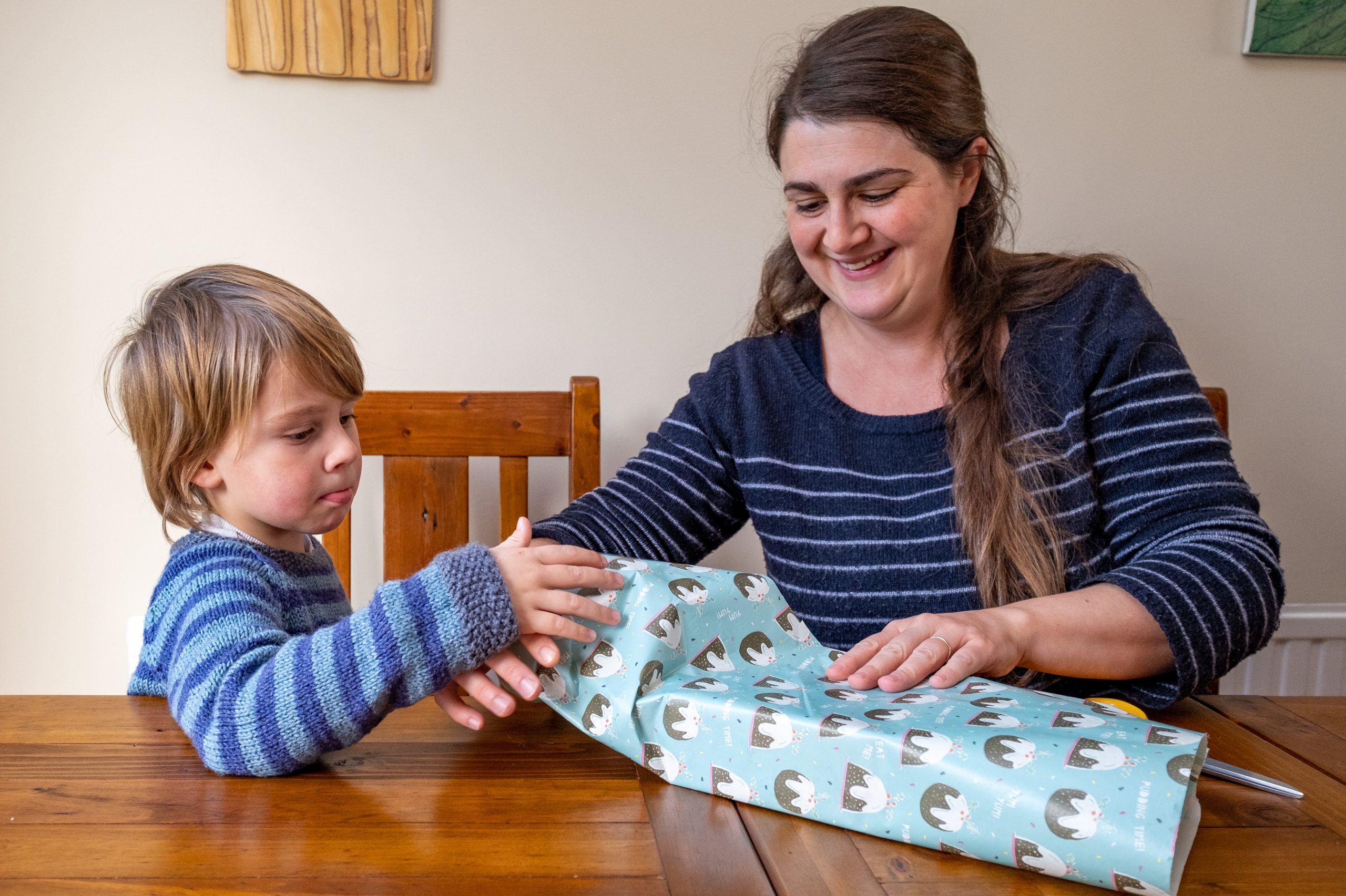 Foster carer and child wrapping presents