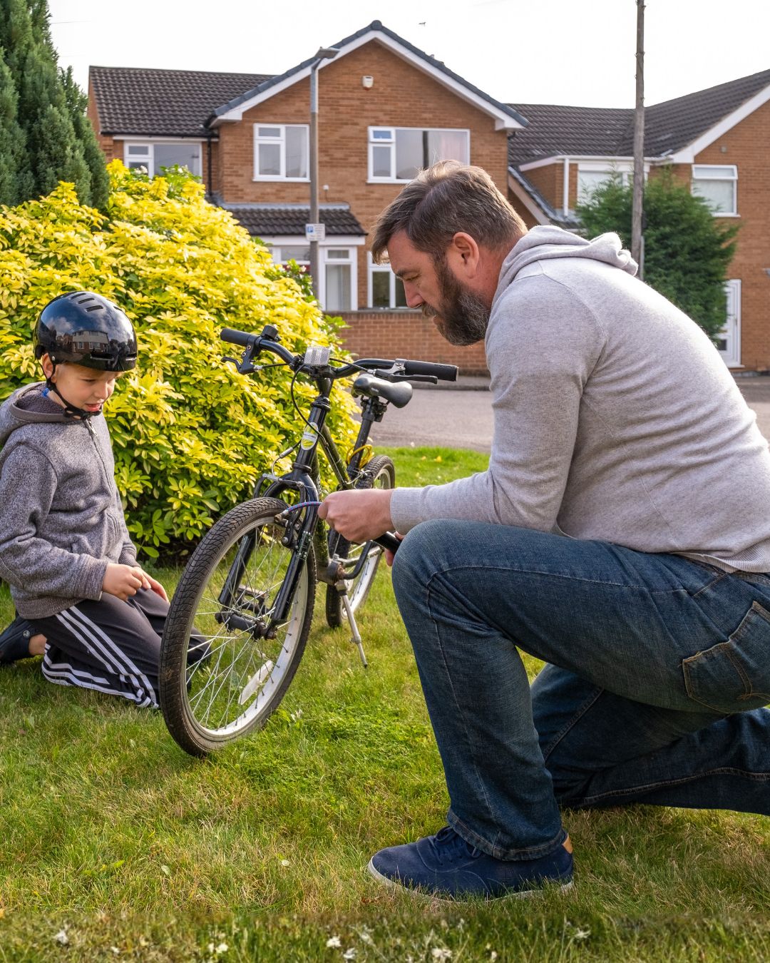 a foster carer helping their foster child repair their bike